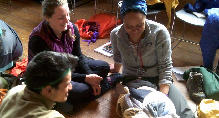 Two people tend to another during a wilderness first responder exercise. 